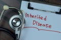 Concept of Inherited Disease write on a paperwork with stethoscope isolated on Wooden Table