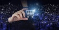 The concept of Innovation in e-Commerce. Hand hold digital hologram cart sign on city dark blurred background. Online shopping or