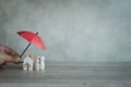 The concept of insurance for home and life. A small umbrella over the house and a family figure Royalty Free Stock Photo