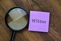 Concept of Interim write on sticky notes isolated on Wooden Table