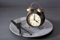 Concept of intermittent fasting, ketogenic diet, weight loss. alarmclock fork and knife on a plate Royalty Free Stock Photo