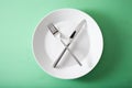 Concept of intermittent fasting and ketogenic diet, weight loss. fork and knife crossed on a plate