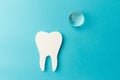 The concept of the International Day of the Dentist. Paper tooth and glass globe on a blue background. Top view Royalty Free Stock Photo