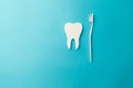 The concept of the International Day of the Dentist. A white toothbrush and a paper tooth on a blue background Royalty Free Stock Photo