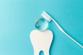 The concept of the International Day of the Dentist. White toothbrush, paper tooth and glass globe on a blue background Royalty Free Stock Photo