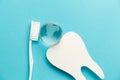 The concept of the International Day of the Dentist. White toothbrush, paper tooth and glass globe on a blue background Royalty Free Stock Photo