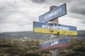 concept international law text quote on wooden signpost outdoors on nato colored flag, ukrainian flag and russian flags