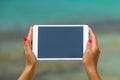 Concept of internet and communication. blank empty tablet computer in the hands of women on the beach Royalty Free Stock Photo