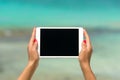 Concept of internet and communication. blank empty tablet computer in the hands of women on the beach Royalty Free Stock Photo