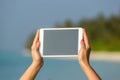 Concept of internet and communication. blank empty tablet computer in the hands of women on the beach Royalty Free Stock Photo