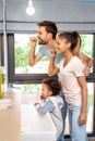 Husband, wife and kid girl brushing teeth in bathroom Royalty Free Stock Photo