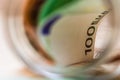 Concept of investing and keeping money, close up . Composition with saving money banknotes in a glass jar. Detail of euro