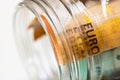 Concept of investing and keeping money, close up isolated. Composition with saving money banknotes in a glass jar. Detail of euro