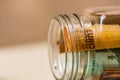 Concept of investing and keeping money, close up isolated. Composition with saving money banknotes in a glass jar. Detail of euro