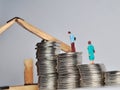 Coin stack,miniature people and house miniature on white