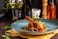 Concept of Italian cuisine. Stewed chicken in strong wine with vegetables. Serving dishes in a restaurant in a blue plate