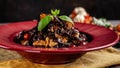 The concept of Italian cuisine. Sweet Pasta papardelle with walnuts nuts and candied fruit. Cocoa black paste. Serving dishes Royalty Free Stock Photo