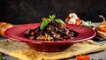 The concept of Italian cuisine. Sweet Pasta papardelle with walnuts nuts and candied fruit. Cocoa black paste. Serving dishes Royalty Free Stock Photo