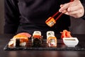 The concept of Japanese cuisine. A girl holds a red Chinese chopsticks and eat sushi in a restaurant. background image Royalty Free Stock Photo