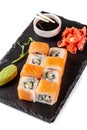 The concept of Japanese cuisine. Rolls with salmon, feta cheese, cucumber. Near soy sauce, ginger and wasabi. Modern serving Royalty Free Stock Photo