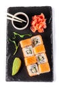 The concept of Japanese cuisine. Rolls with salmon, feta cheese, cucumber. Near soy sauce, ginger and wasabi. Modern serving Royalty Free Stock Photo