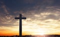 Concept of Jesus Christ: white cross on sunset sky background