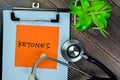 Concept of Ketones write on sticky notes with stethoscope isolated on Wooden Table
