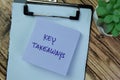 Concept of Key Takeaways write on sticky notes isolated on Wooden Table Royalty Free Stock Photo