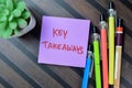 Concept of Key Takeaways write on sticky notes isolated on Wooden Table Royalty Free Stock Photo