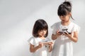 Concept kids and gadgets. Two little girls siblings sisters look at the phone. They hold a smartphone watch videos, learn, play