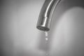 The concept of lack of drinking water. Fluid leaks and drips down. A drop of water drains from the faucet Royalty Free Stock Photo
