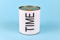 Concept of lack of time showing a tin can with white label and word `Time` on blue background