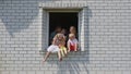 The concept of a large family. A friendly family hugs each other in the window of their house.