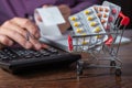 Concept of large spending on medicines. Shopping cart full of medicines and pills