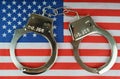 There are handcuffs on the US flag.