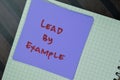Concept of Lead by Example write on sticky notes isolated on Wooden Table Royalty Free Stock Photo