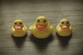 Concept of leader and follower. Selective focus of a small toy duck and big duck in a row on wooden background