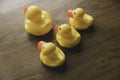 Concept of leader and follower. Selective focus of a small toy duck follow a big duck on wooden background