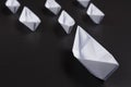 Concept of leadership in business. Origami white ships made of paper on black background. Royalty Free Stock Photo