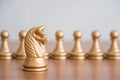 Concept of leadership, think different and recruitment employee. Knight chess leading pawns on wooden table. Leadership skills