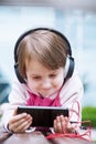 Concept: Learning is everywhere and anytime. Little child girl using mobile phone watching online e-learning video to studying Royalty Free Stock Photo