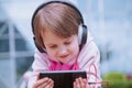 Concept: Learning is everywhere and anytime. Little cute child girl using mobile phone watching online e-learning video to Royalty Free Stock Photo