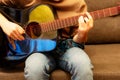 Concept of learning to play the guitar. Man playing and practicing guitar. Male hands playing black acoustic guitar with red