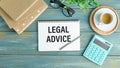 Concept Legal Advice message on notebook with glasses, pencil and coffee cup on wooden table Royalty Free Stock Photo