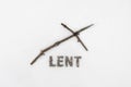 Concept for Lent Season. Wooden Cross or crucifix and text made of ashes on snow background Royalty Free Stock Photo