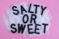 Concept. Letters for the Words Salty or Sweet in heap of salt and sugar