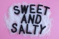 Concept. Letters for the Words Salty and Sweet in heap of salt and sugar