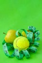 Concept of light food and eco lifestyle, Apples in bright green color and tennis ball and twisted measure tape