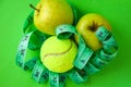 Concept of light food and eco lifestyle, Apples in bright green color and tennis ball and twisted measure tape