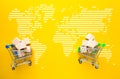 Trolleys with boxes of goods on yellow background. The concept of logistics and delivery of goods